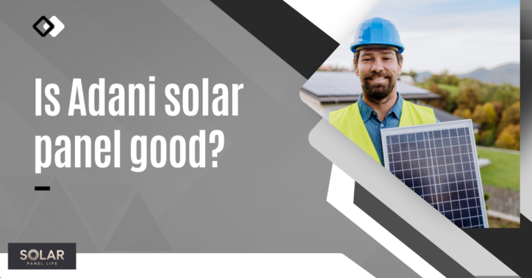 A smiling man in a safety helmet holding a solar panel with a house and green hills in the background.